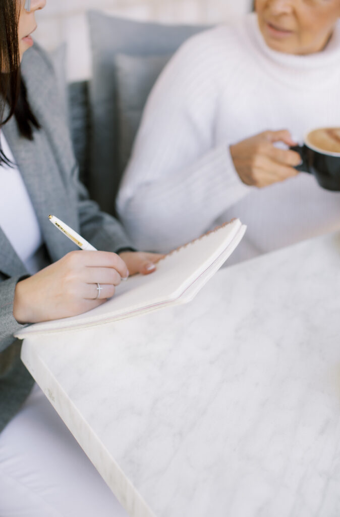 women working while taking notes and drinking coffee