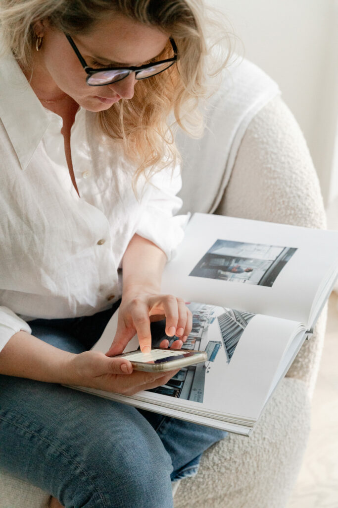 Woman looking for rebranding inspiration, blond hair, white shirt, glasses in tan chair